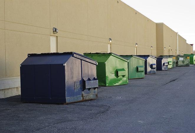 a forklift lifts a full dumpster from a work area in Arizona City